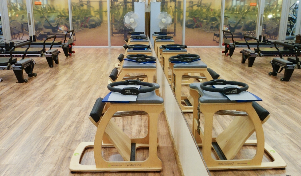 wooden pilates equipment in front of large mirror at the body kinetics san rafael gym